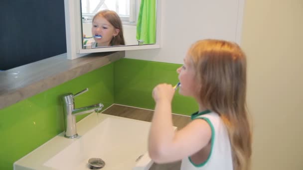 Girl brushing his teeth in the mirror — Stock Video