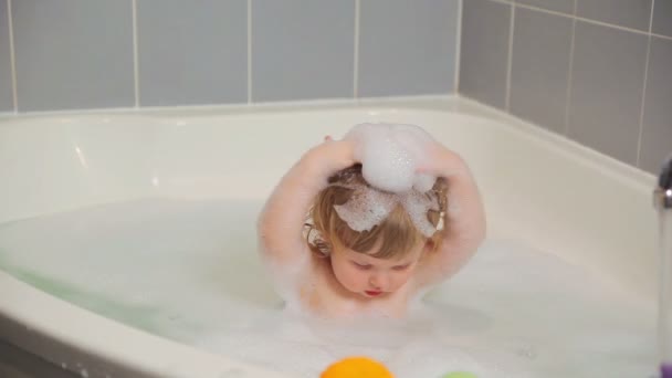 Chica juega en una bañera con espuma — Vídeos de Stock