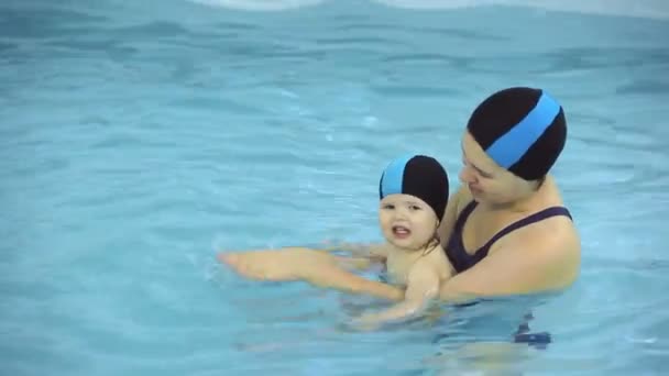 Madre enseña a niña a nadar en una piscina — Vídeos de Stock