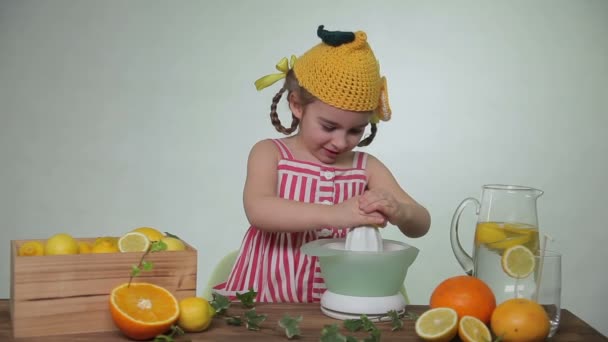 Girl squeezes out juice of a lemon — Stock Video