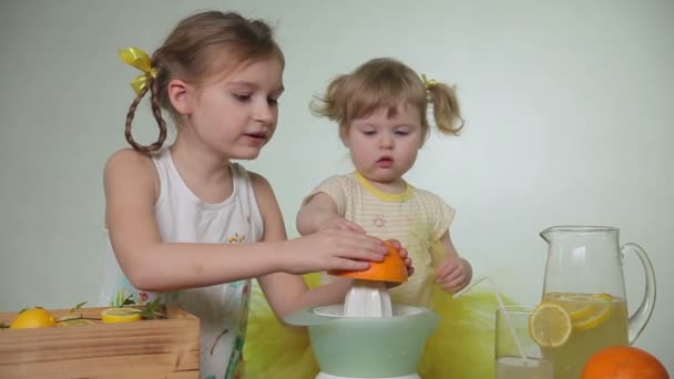 Dívky vymačkejte šťávu z pomeranče — Stock video