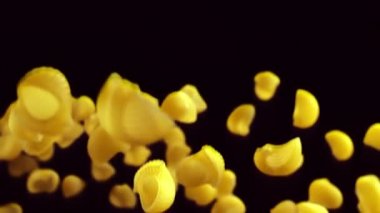 siyah bir arka plan üzerine düşen makarna