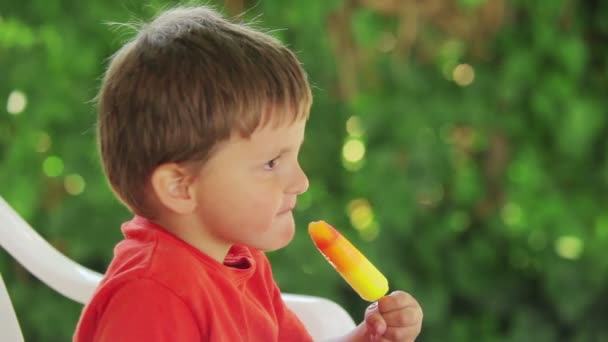 Мальчик ест мороженое — стоковое видео