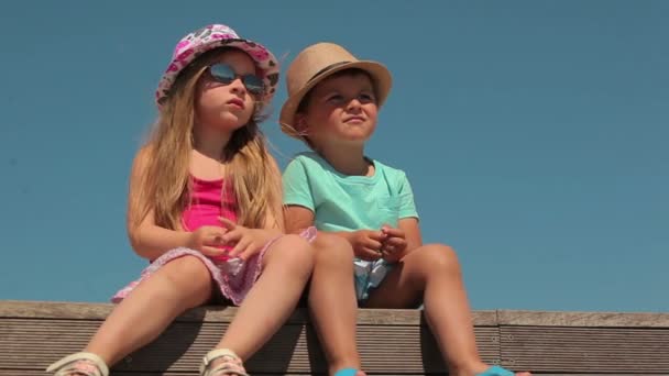 Little boy and girl sitting on a pier Yacht Club — Stock Video