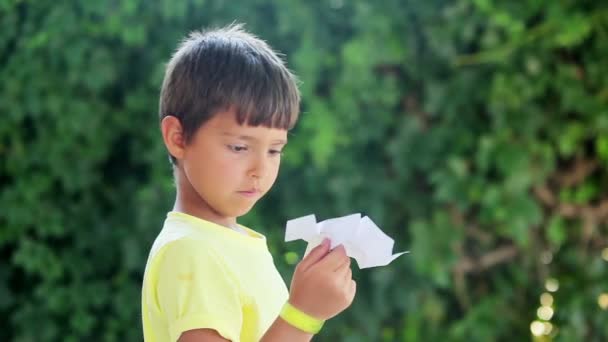 Jongen begint papier vliegtuig — Stockvideo