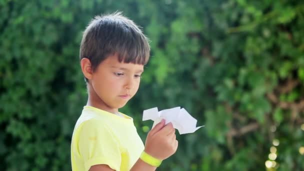 Chico comienza avión de papel — Vídeo de stock