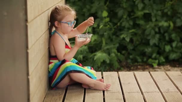 Meisje eten pap vergadering — Stockvideo