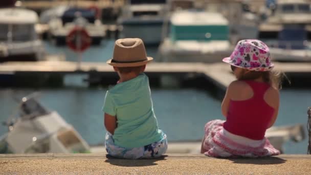 Μικρό αγόρι και κορίτσι που κάθεται σε μια προβλήτα — Αρχείο Βίντεο