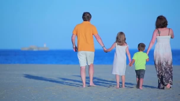 Familie geht am Strand spazieren — Stockvideo