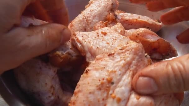 Super close-up de mãos masculinas misturando asas de frango com especiarias — Vídeo de Stock