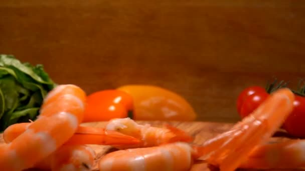 Panorama of delicious peeled shrimps falling on the wooden board — Stock Video