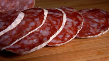 Ahşap bir tahtadan çatalla alınan lezzetli kuru sosis manzarası.