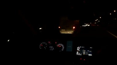 Araba gece trafiğinde caddede ilerliyor.
