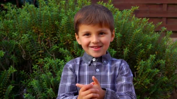 El adorable niñito sonríe y cuenta con los dedos al aire libre — Vídeos de Stock