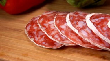 Tahta bir tahtadan çatalla alınmış nefis kuru sosislerin süper yakın çekimi.