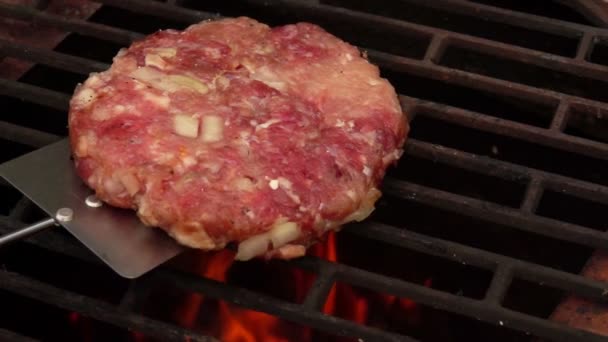 Escalope crue maison pour un hamburger est placé sur la grille de grill au-dessus du feu ouvert — Video