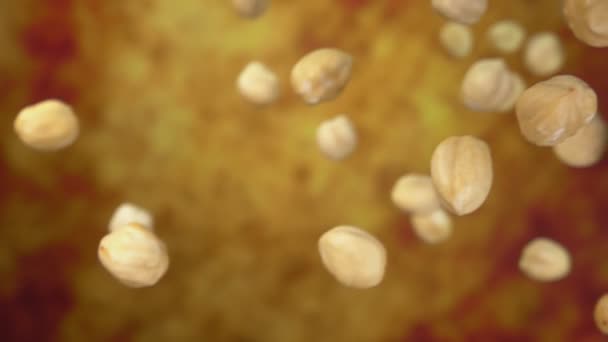 Close-up de avelãs descascadas caindo em um fundo ocre amarelo — Vídeo de Stock