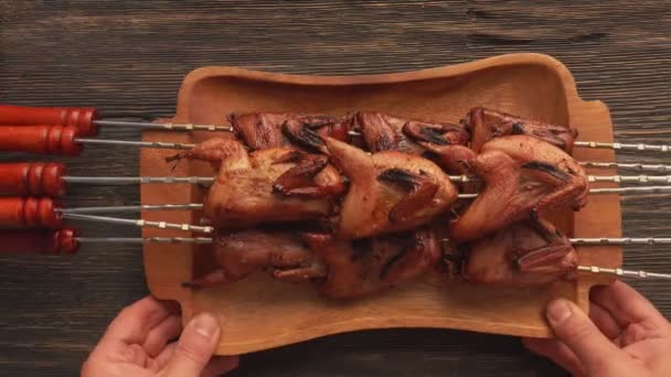 Top view of a plate full of grilled quails on the skewers placed on the table — Stock Video