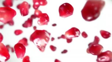 Beyaz arka planda seken olgun nar tanelerini yakından çek.