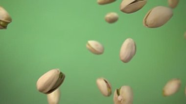 Tuzlu şam fıstıklarının yakın plan yeşil arka planda çapraz uçuşu