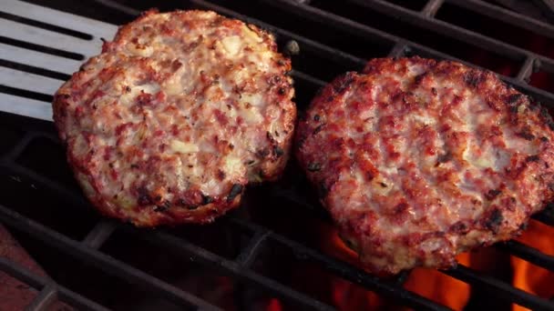 Deux délicieuses escalopes de hamburger à la viande aux oignons sont retournées avec une spatule de cuisine — Video