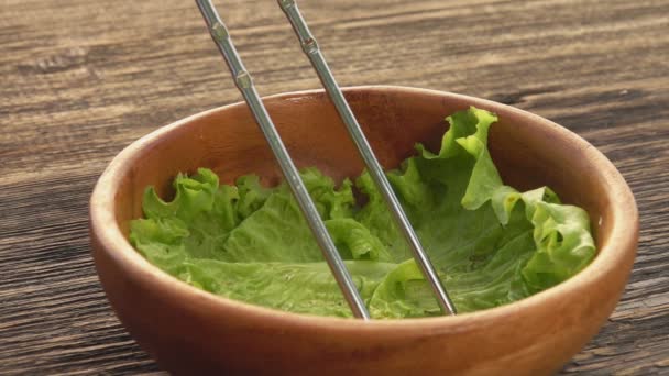 Close-up of a chicken wing taking down from the skewer into the wooden bowl — Stock Video