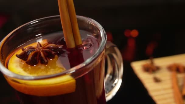 De kaneelstokje valt in een glas met glühwein. — Stockvideo