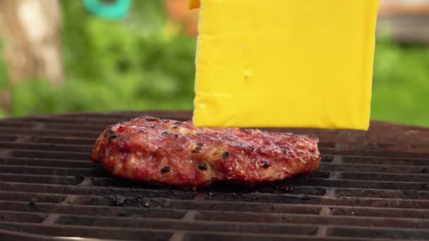 Сир Чеддер поміщають на саморобну котлетку для бургер на решітці гриля — стокове відео