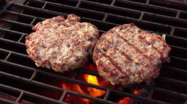 Izgarada kızaran ev yapımı hamburgerlerin yakın çekim manzarası.