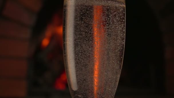 シャンパンは火を背景に背の高いガラスに注ぐ — ストック動画