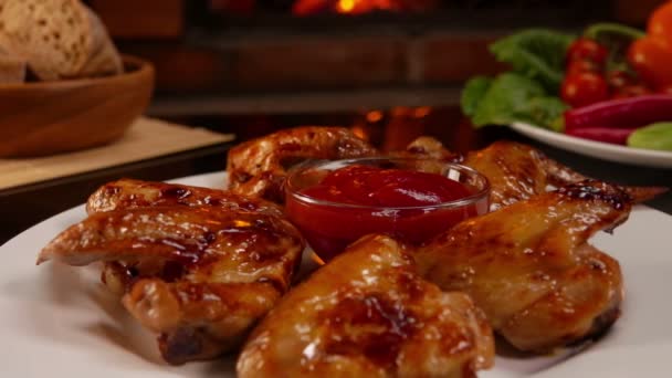Panorama of the plate with grilled chicken wings and ketchup on the glass table — Stock Video