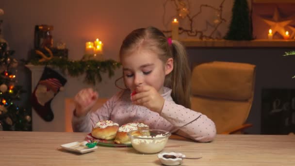 Menina está colocando as pequenas velas nos deliciosos rolos de canela — Vídeo de Stock
