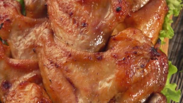 Κοντινό πανόραμα με τηγανητές φτερούγες κοτόπουλου στα σουβλάκια στο ξύλινο πιάτο — Αρχείο Βίντεο