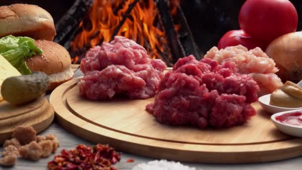 Kuřecí, hovězí a vepřové mleté maso na desce na pozadí ohně — Stock video