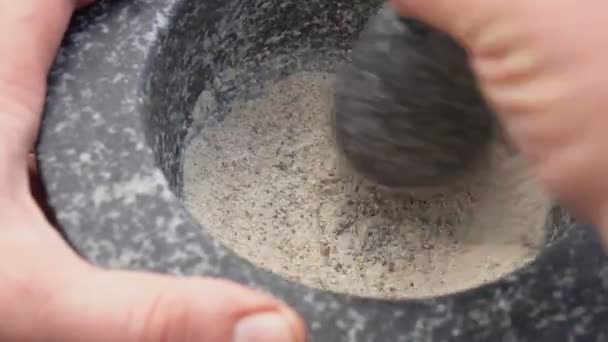 Primer plano del mortero mezclando especias en el mortero de piedra gris — Vídeos de Stock