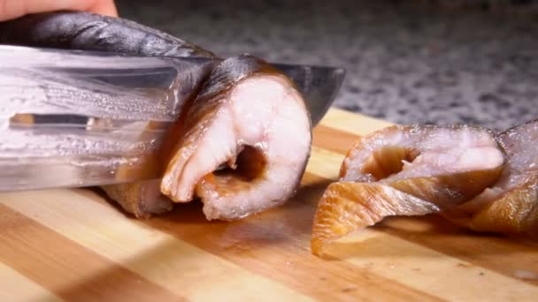 Close-up de mãos femininas cortando enguia defumada em porções em uma placa — Vídeo de Stock