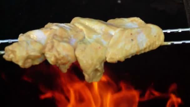 Primer plano de las brochetas con las alas de pollo crudo colocadas sobre el fuego abierto — Vídeos de Stock