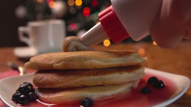 Close-up of the confectionery syringe decorating a stack of pancakes with cream — Stock Video