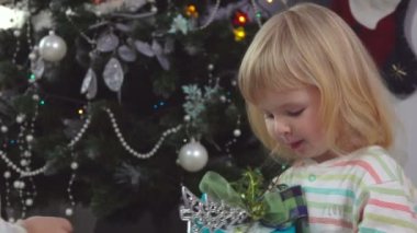 Pijamalı küçük tatlı kız Noel sabahı hediye kutusunu alıyor.