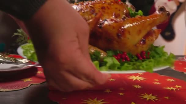 크리스마스 식탁에 구운 닭고기를 놓고 있는 여성 손의 파노라마 — 비디오