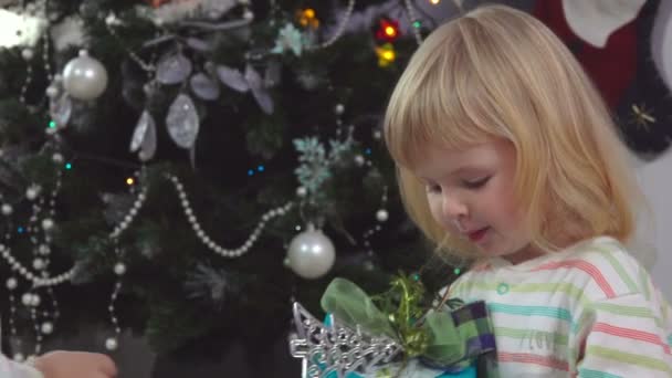 Menina bonito criança no pijama está levando sua caixa de presente na manhã de Natal — Vídeo de Stock
