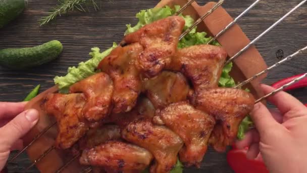 Top view of delicious fried chicken wings on the skewers placed on the table — Stock Video