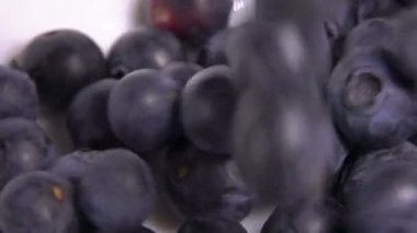 Böğürtlenlerin süper yakın çekimi beyaz kaseye düşüyor.