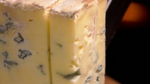 Κοντινό πλάνο του νόστιμου μπλε τυρί Roquefort που πέφτει σε μια ξύλινη σανίδα — Αρχείο Βίντεο