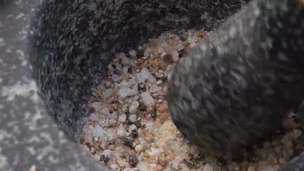 Primo piano della frantumazione dei pestelli e della miscelazione di sale e spezie nella malta grigia di pietra — Video Stock