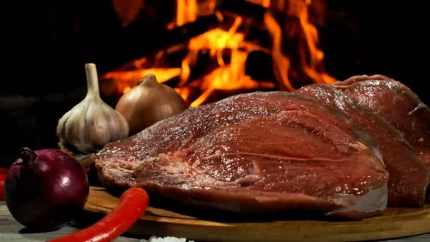 Lahodný syrový hovězí steak ležel na dřevěné desce vedle cibule a chilli — Stock video