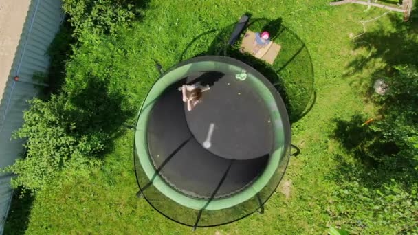 Luchtfoto van een blond meisje springen en rennen op de trampoline — Stockvideo