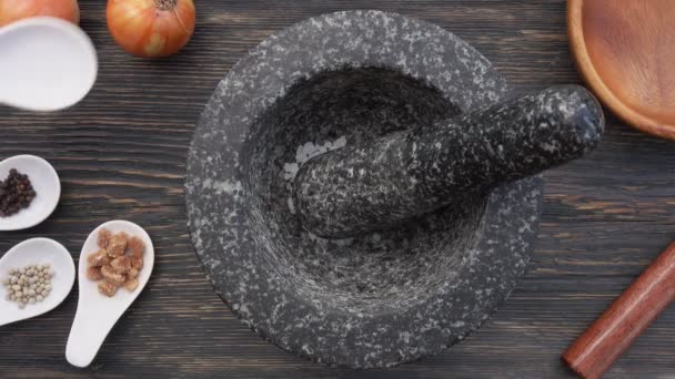 Draufsicht auf Salz, braunen Zucker und Pfefferkörner, die in den grauen Steinmörtel fallen — Stockvideo