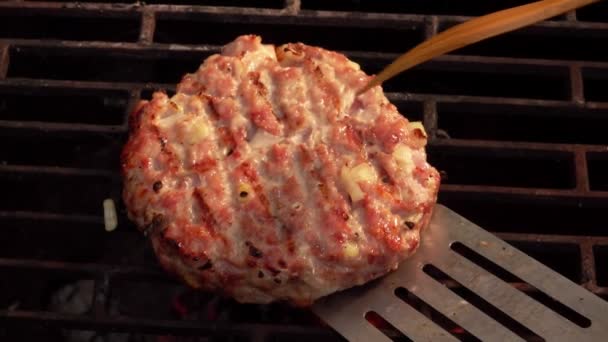 Vue de dessus de la délicieuse escalope de hamburger retournée sur le gril avec une spatule — Video