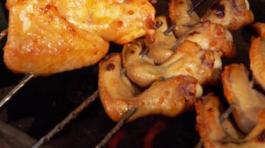 Ateşin üstünde salamura edilmiş tavuk kanatlarının yakın çekimi.